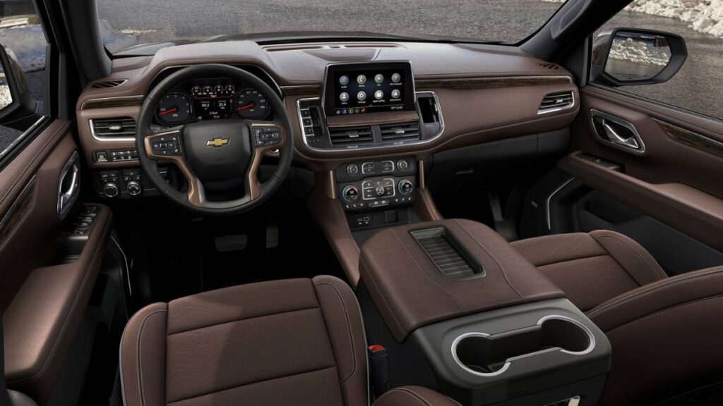 2023 Chevrolet Suburban interior showing three rows of spacious seating for up to nine passengers, leather upholstery, 10.2-inch touchscreen display, and premium luxury cabin materials