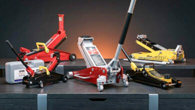 Floor jack lifting a vehicle in a home garage