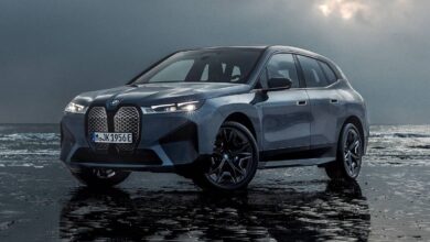 2023 BMW iX front view featuring illuminated kidney grille and futuristic electric SUV design