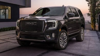 2023 GMC Yukon front three-quarter view showing C-shaped headlights, imposing grille, and squared proportions