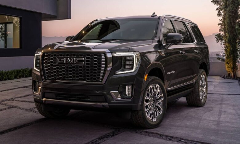 2023 GMC Yukon front three-quarter view showing C-shaped headlights, imposing grille, and squared proportions