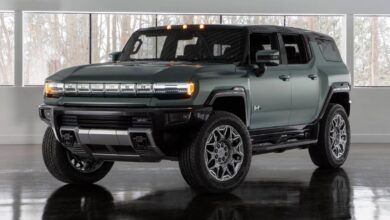 2024 GMC Hummer EV SUV front view, massive grille and LED headlights.