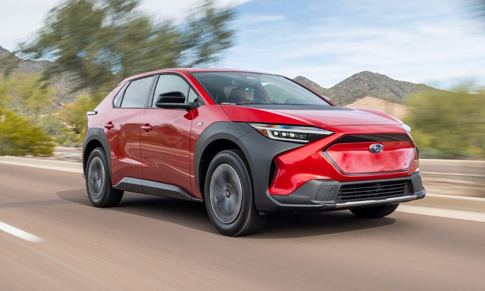 2023 Subaru Solterra front view in red showcasing LED headlights, standard all-wheel drive, and rugged electric SUV styling