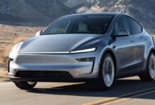 2026 Tesla Model Y driving on the road front rolling shot