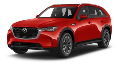 2026 Mazda CX-90 black SUV parked on a scenic road with mountains and sunset background